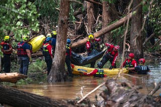 Firefighters from Ciudad Acuña, Mexico, load a body into a raft as they prepare for a water recovery along the Guadalupe River days after a flash flood swept through the area, Monday, July 7, 2025, in Ingram, Texas